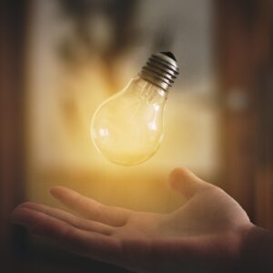 lightbulb shining above a hand